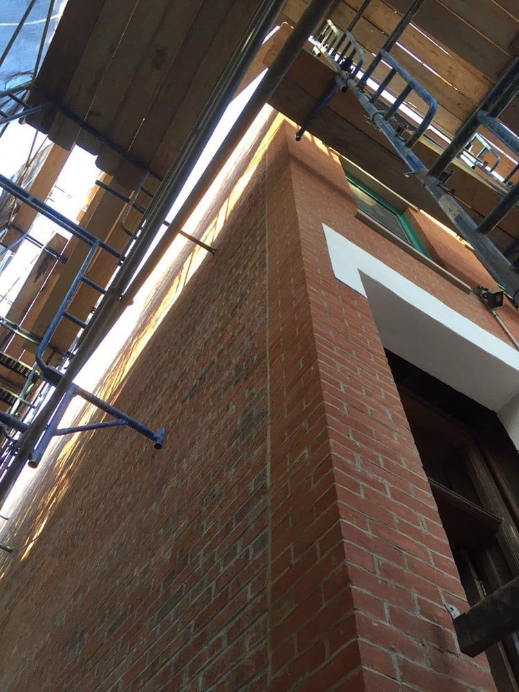 Looking up at a brick building with scaffolding around it