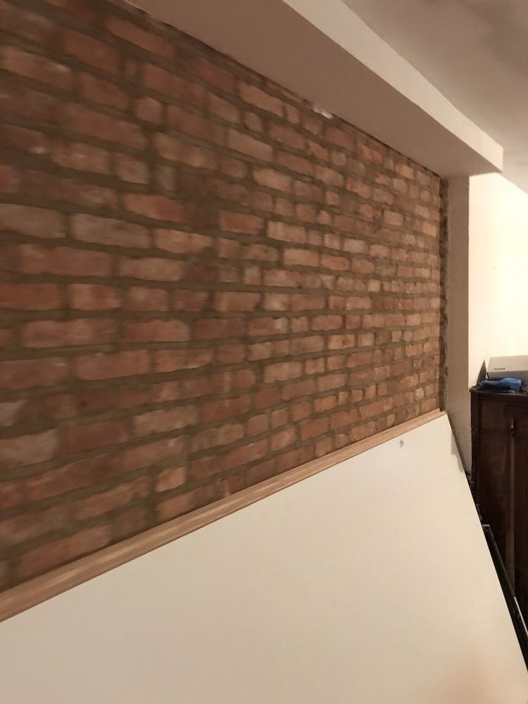 A brick wall with a white trim in a room.