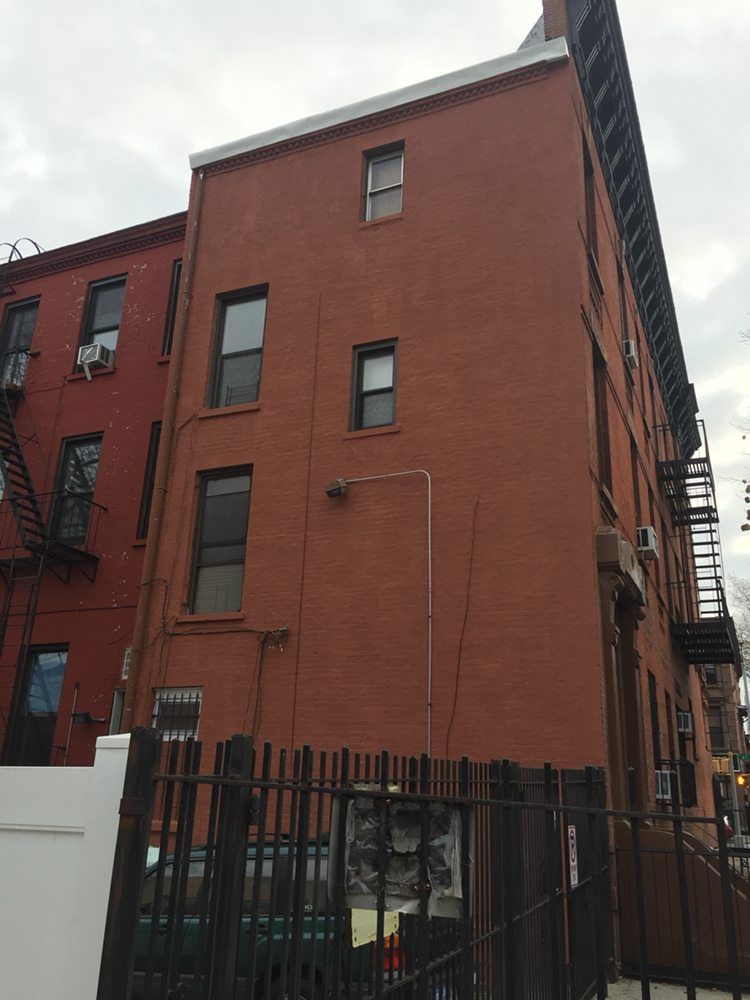 A large red brick building with a fire escape