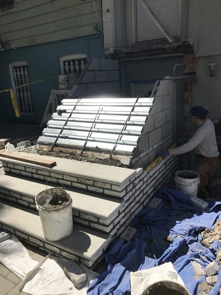 A man is laying bricks on a staircase.