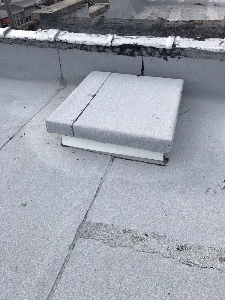 A square concrete block is sitting on top of a roof.