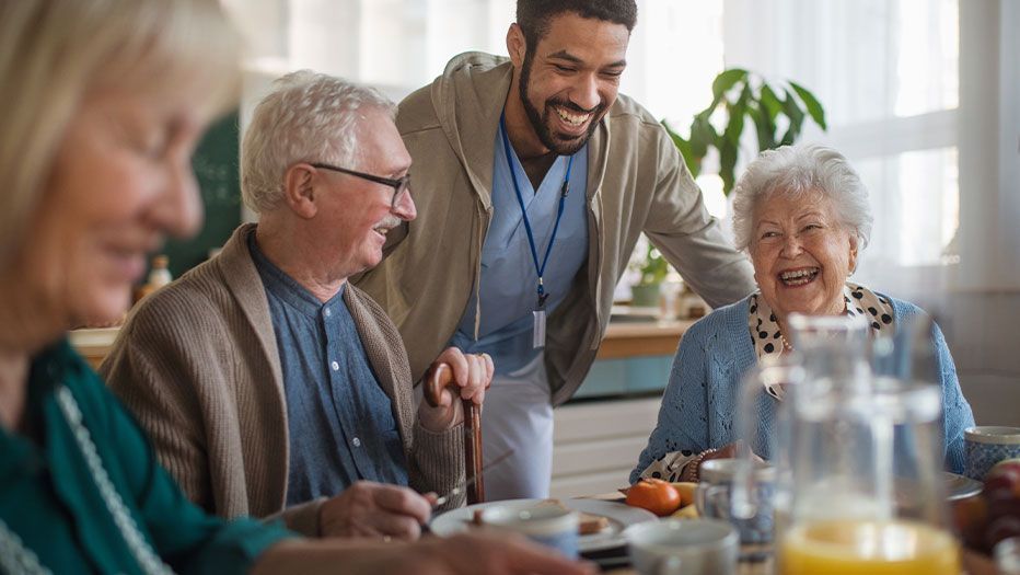 Seniors eating with caregiver