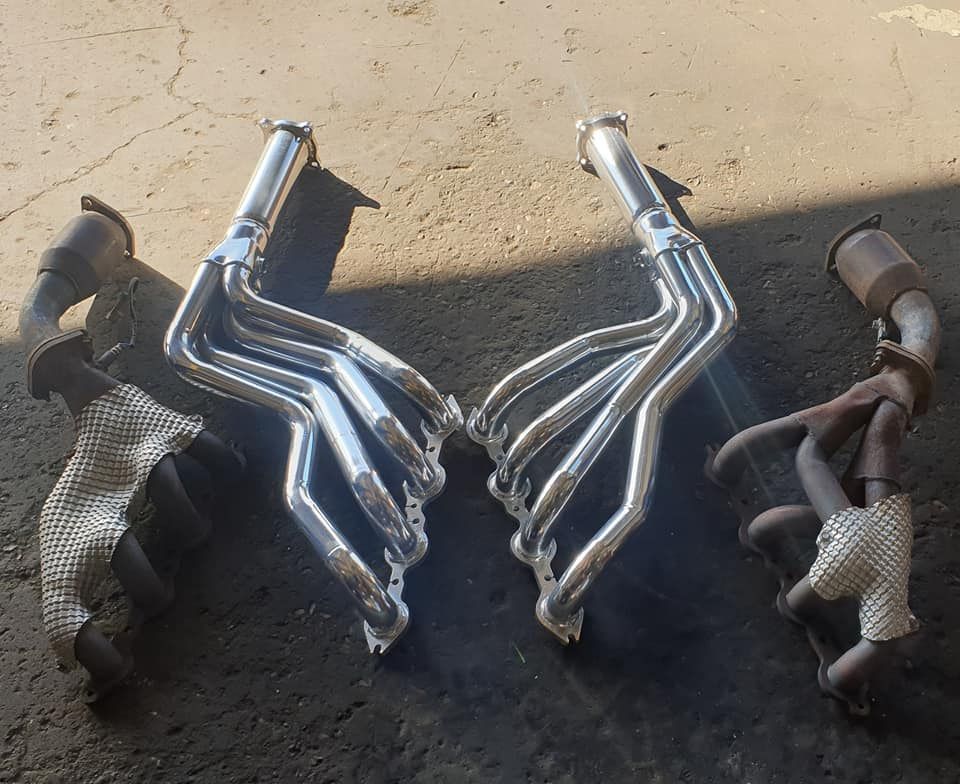 A Pair of Exhaust Pipes Are Sitting on the Ground — Powerhouse Auto Repairs Bundaberg in Bundaberg East, QLD
