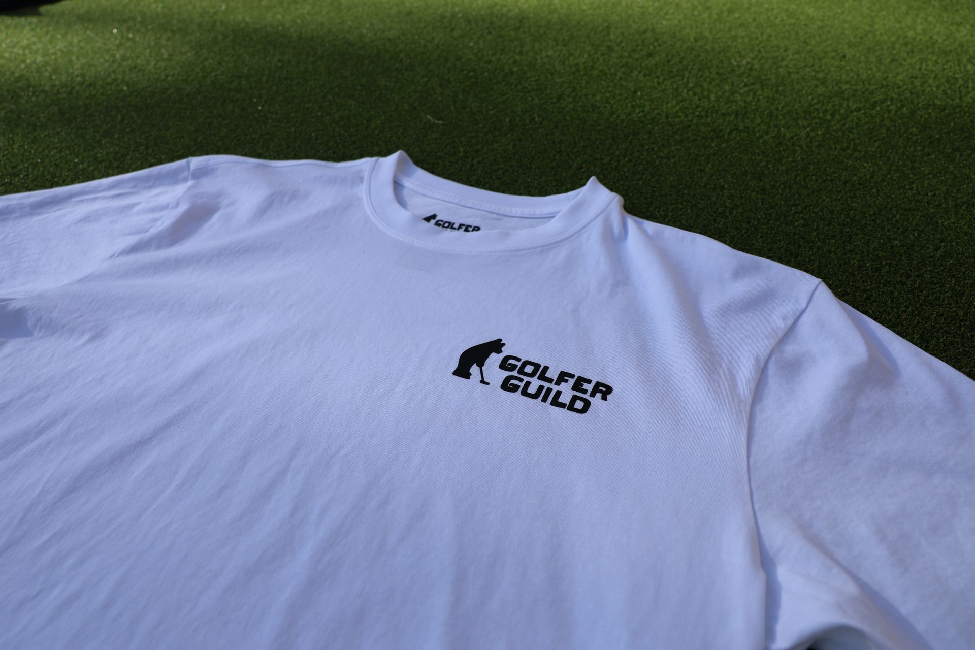 Golfer Guild SUPIMA® cotton Tartan Swinger tee with highland cow golfing animal art by Jonas Claesson.