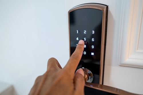 A Man's Hand Is Pressing The Numbers On The Digital Door Lock To Open It - Bolingbrook, IL - Master Locksmithing Inc