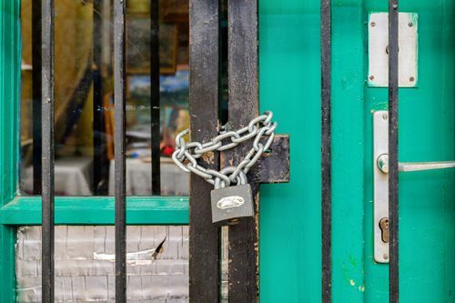 A Green Door Is Locked With A Padlock And Chain - Bolingbrook, IL - Master Locksmithing Inc
