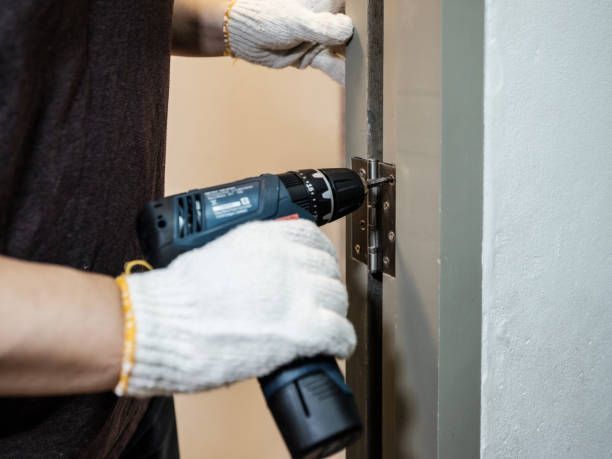 A Man Is Using A Drill To Fix A Door Hinge - Bolingbrook, IL - Master Locksmithing Inc
