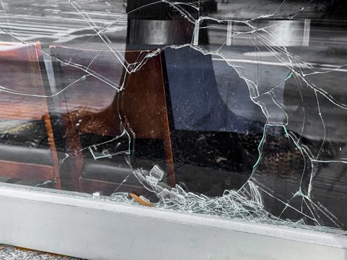 A Broken Glass Window With A Chair In The Background - Bolingbrook, IL - Master Locksmithing Inc