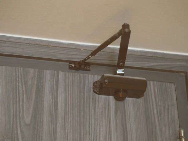A Close Up Of A Door Closer On A Wooden Door - Bolingbrook, IL - Master Locksmithing Inc