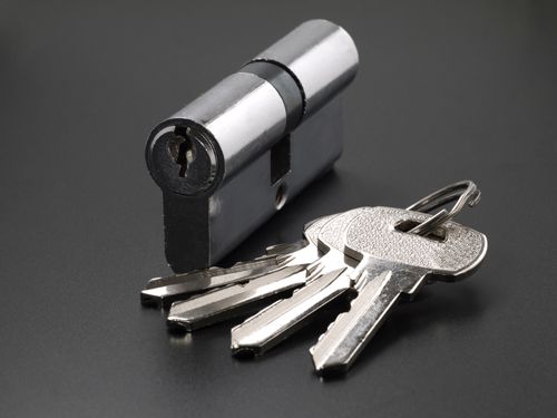 A Bunch Of Keys And A Key Cylinder On A Black Surface - Bolingbrook, IL - Master Locksmithing Inc
