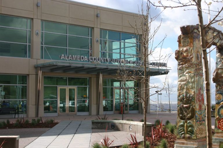 Alameda County Library with glass facade, and decorative arch in the foreground.