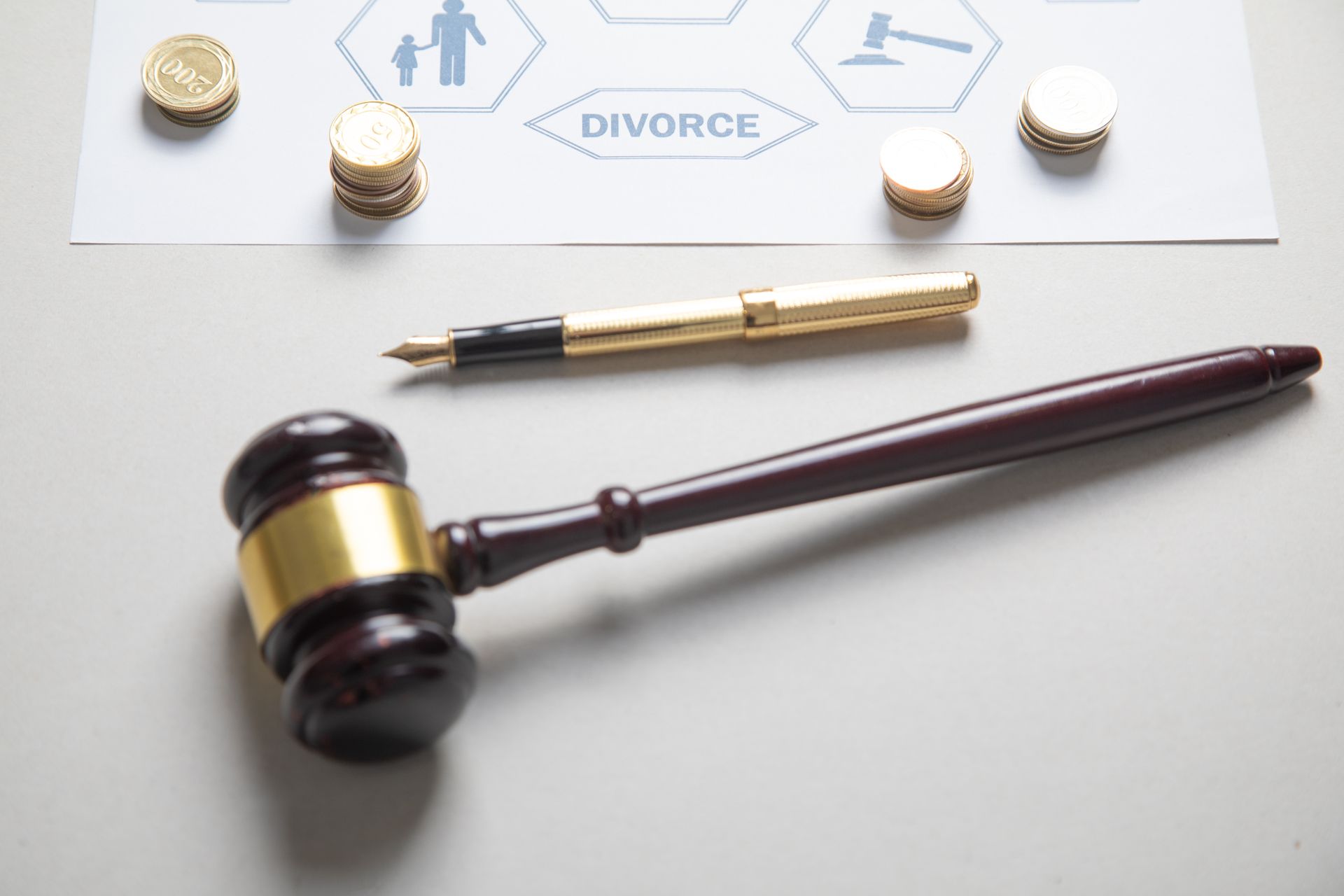 Gavel and pen beside a document with coins, and the word 