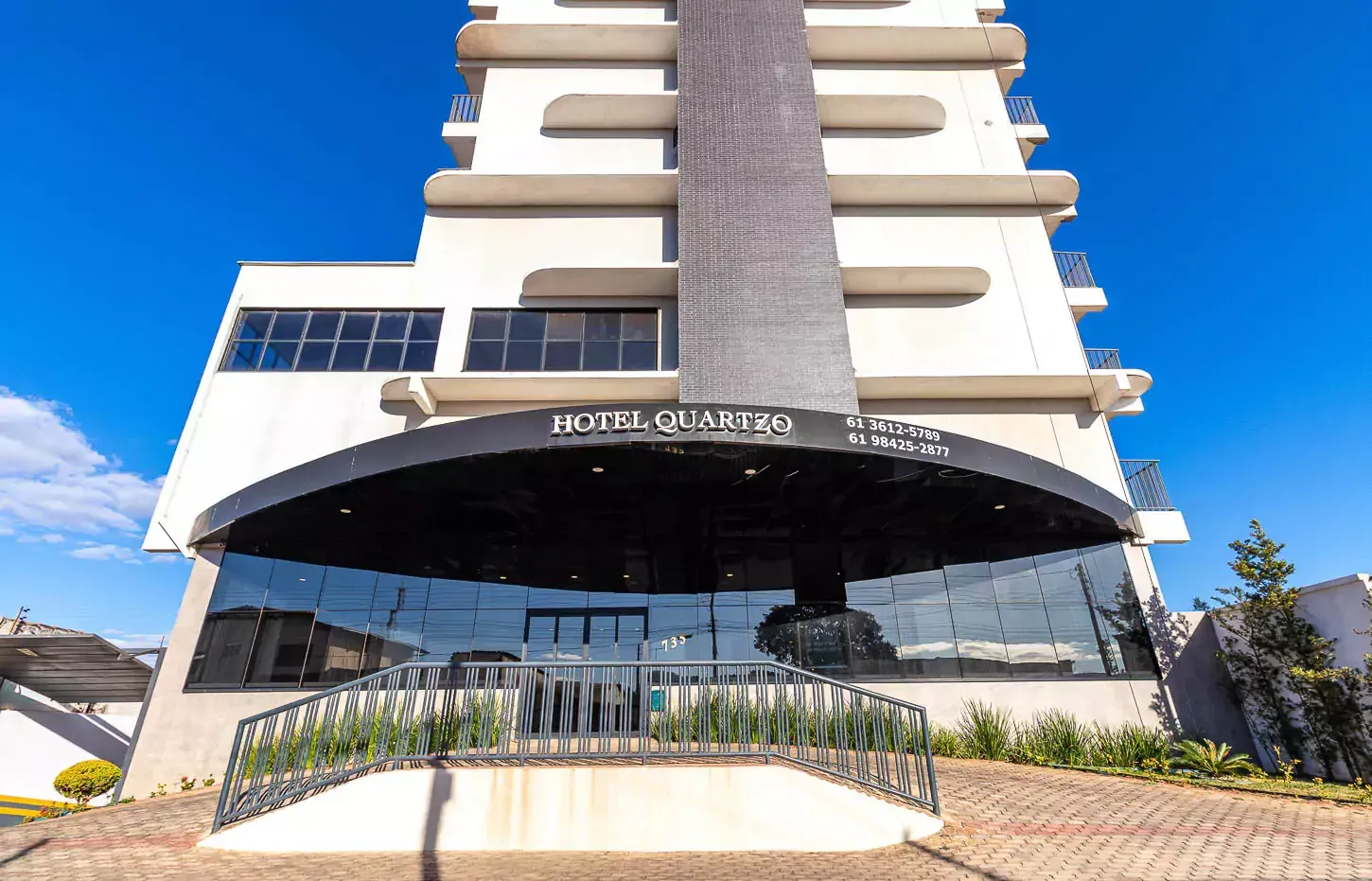 Um grande edifício com muitas janelas e uma ponte na frente dele Hotel Quartzo Cristalina