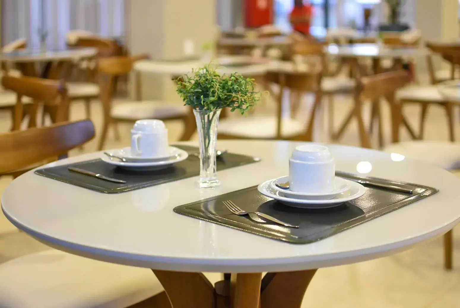 Uma mesa redonda com pratos e xícaras em um restaurante Hotel Quartzo Cristalina
