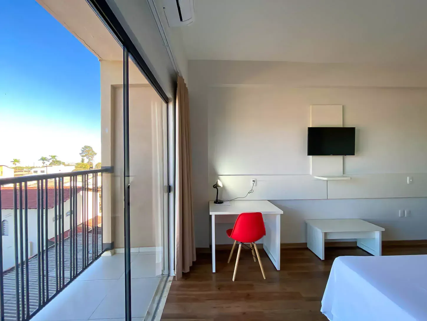 Um quarto de hotel com uma cama, uma escrivaninha e uma televisão - Hotel Quartzo Cristalina