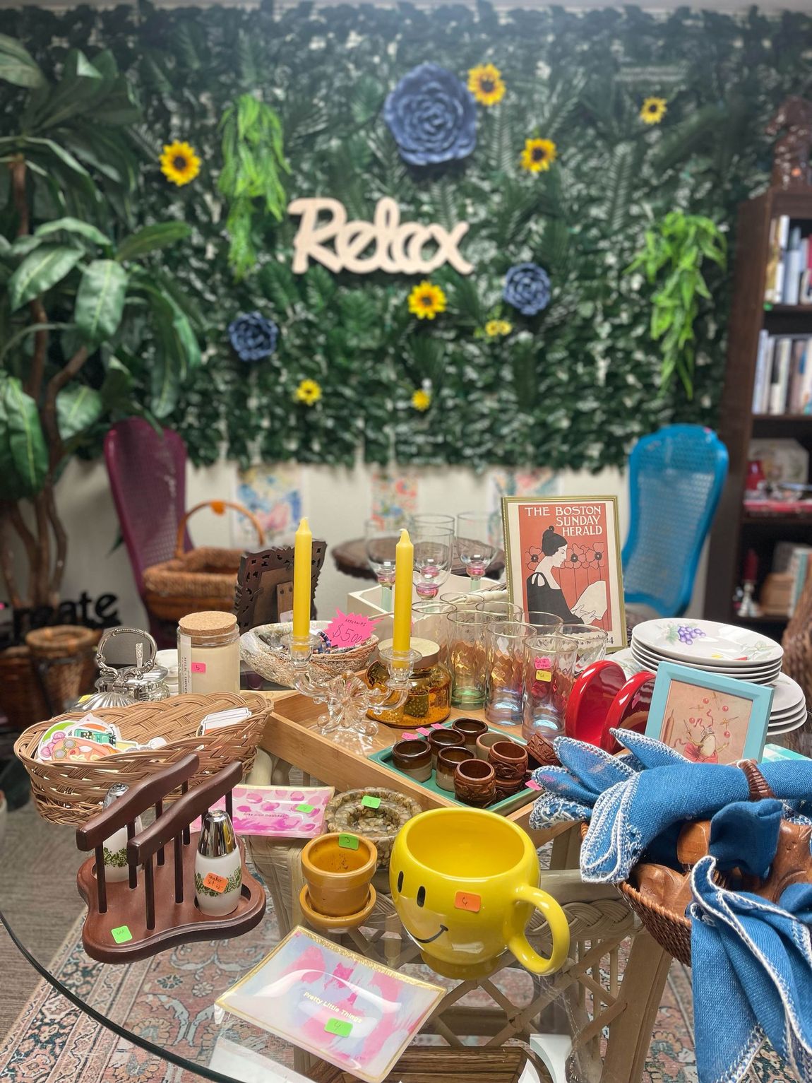 A room with a table and a wall with flowers and a sign that says relax.