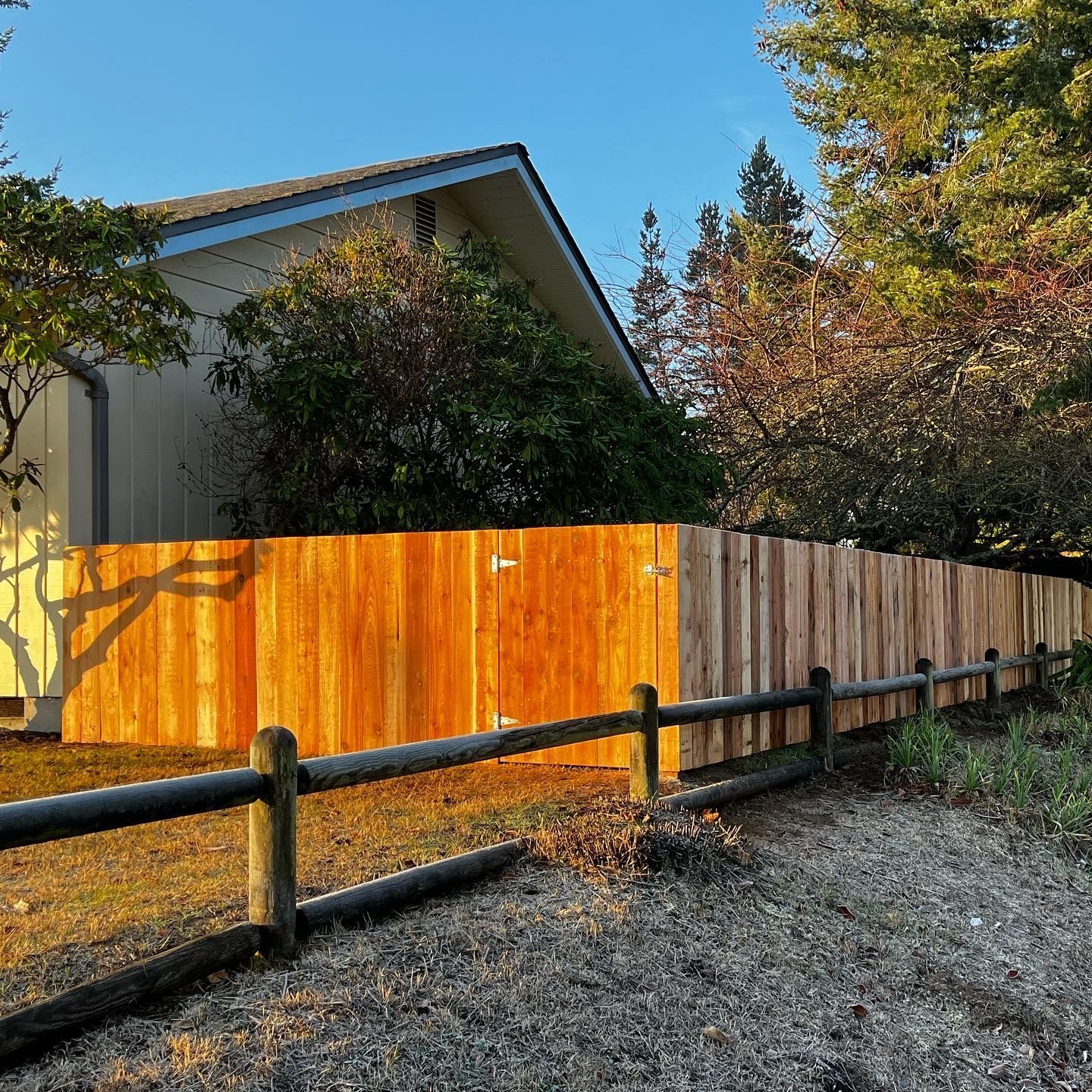 A wooden fence is in front of a house