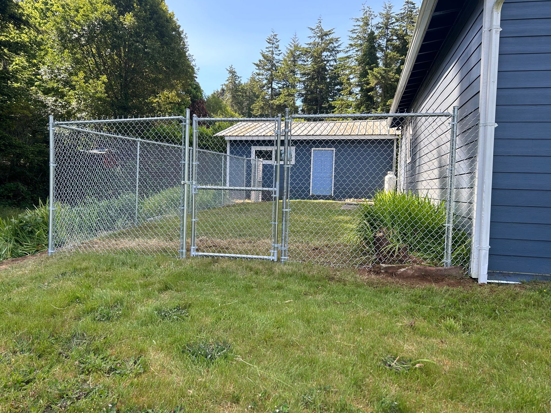 There is a chain link fence in the backyard of a house.