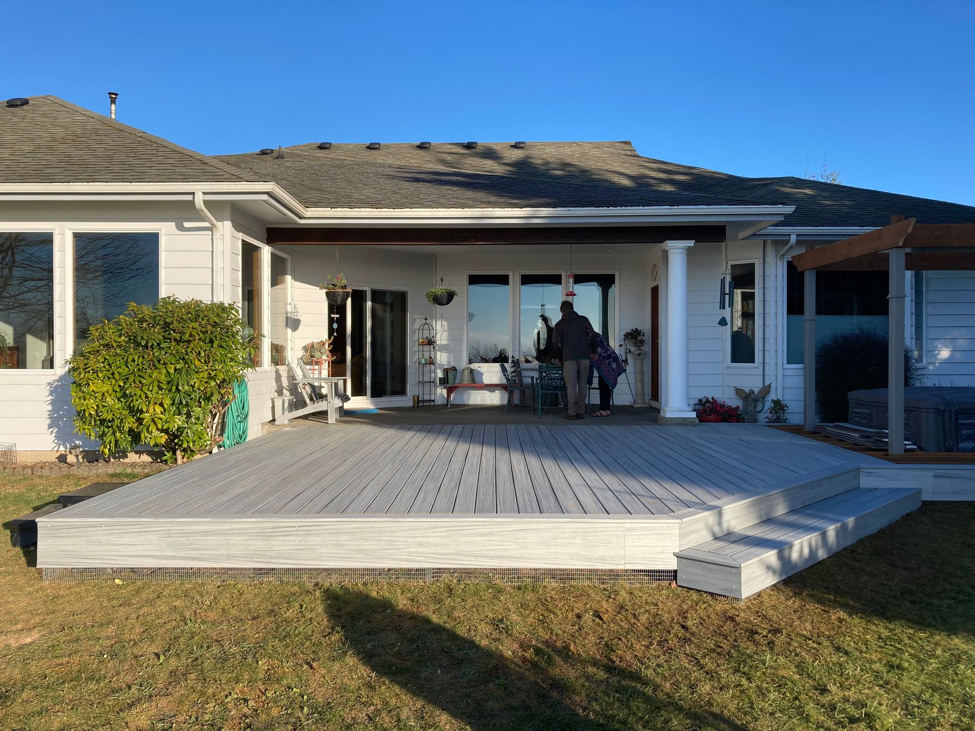 A large white house with a large deck in front of it.