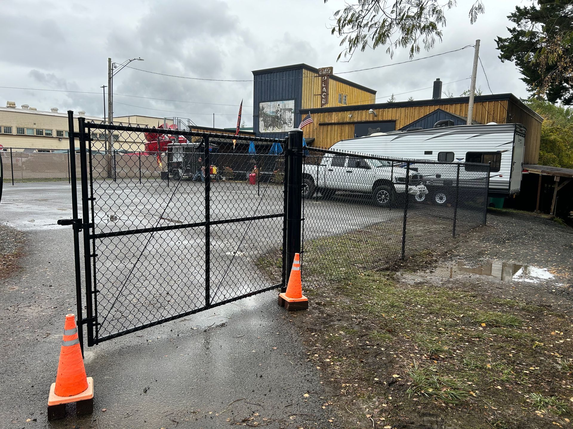 A chain link fence with orange cones in front of it.