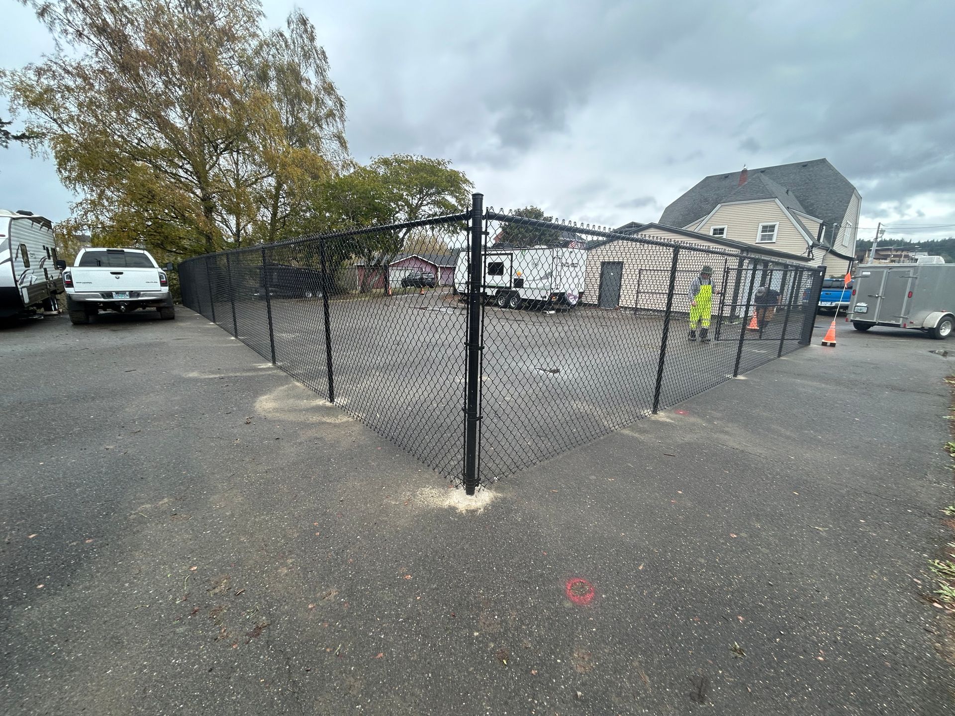 A chain link fence is surrounding a parking lot.