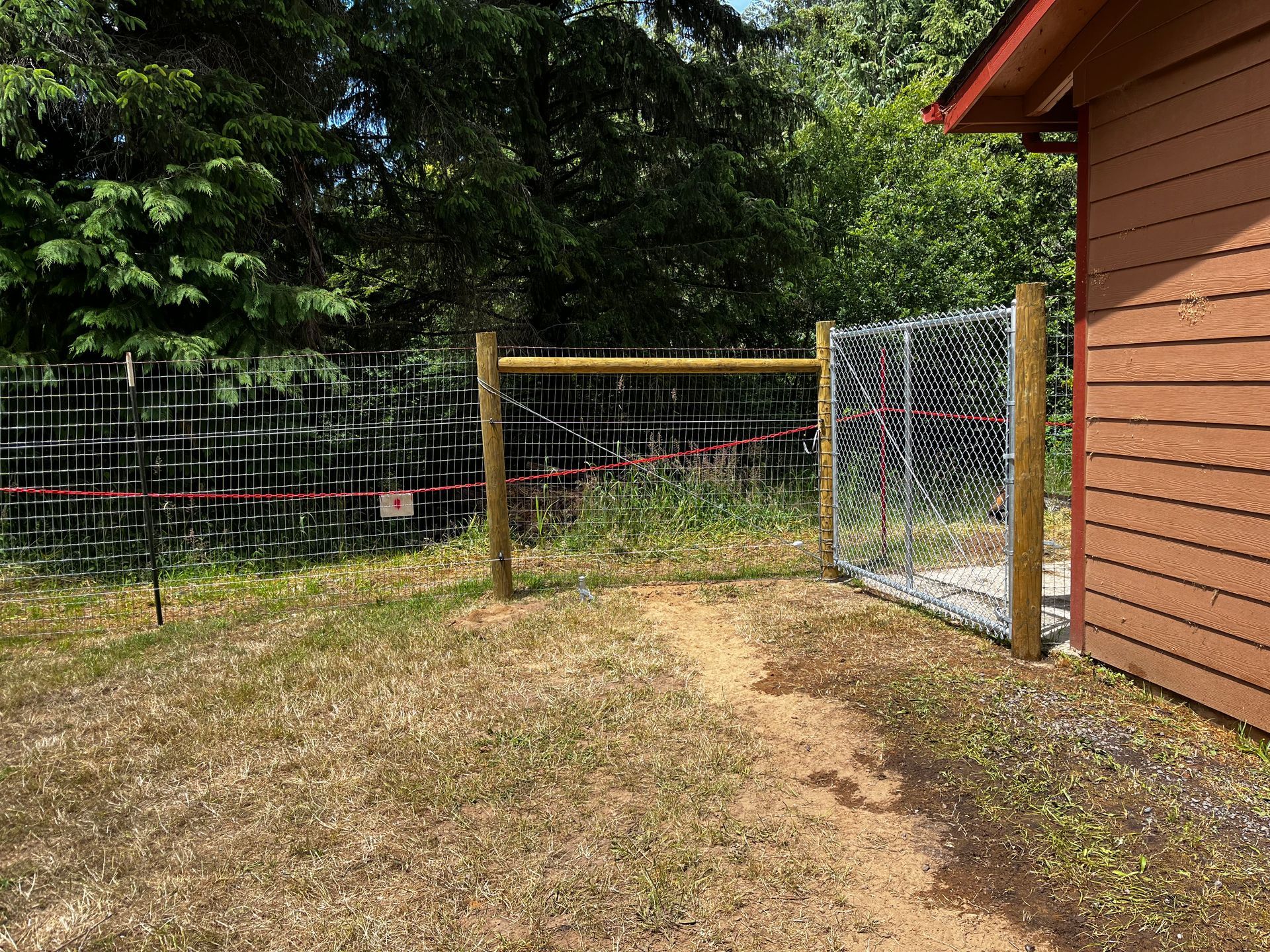 There is a chain link fence in the backyard of a house.