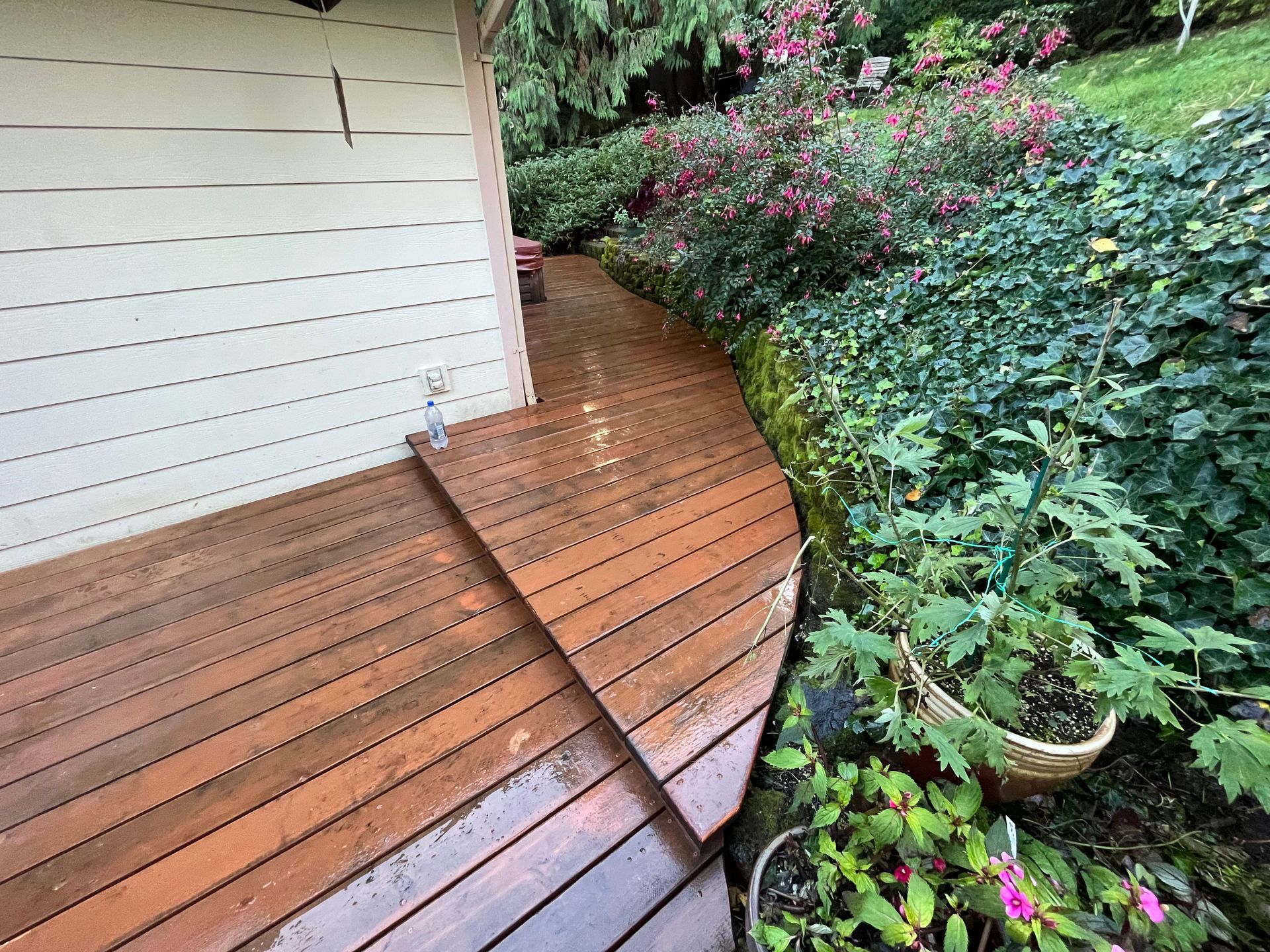 A wooden deck with stairs leading up to it in a garden.