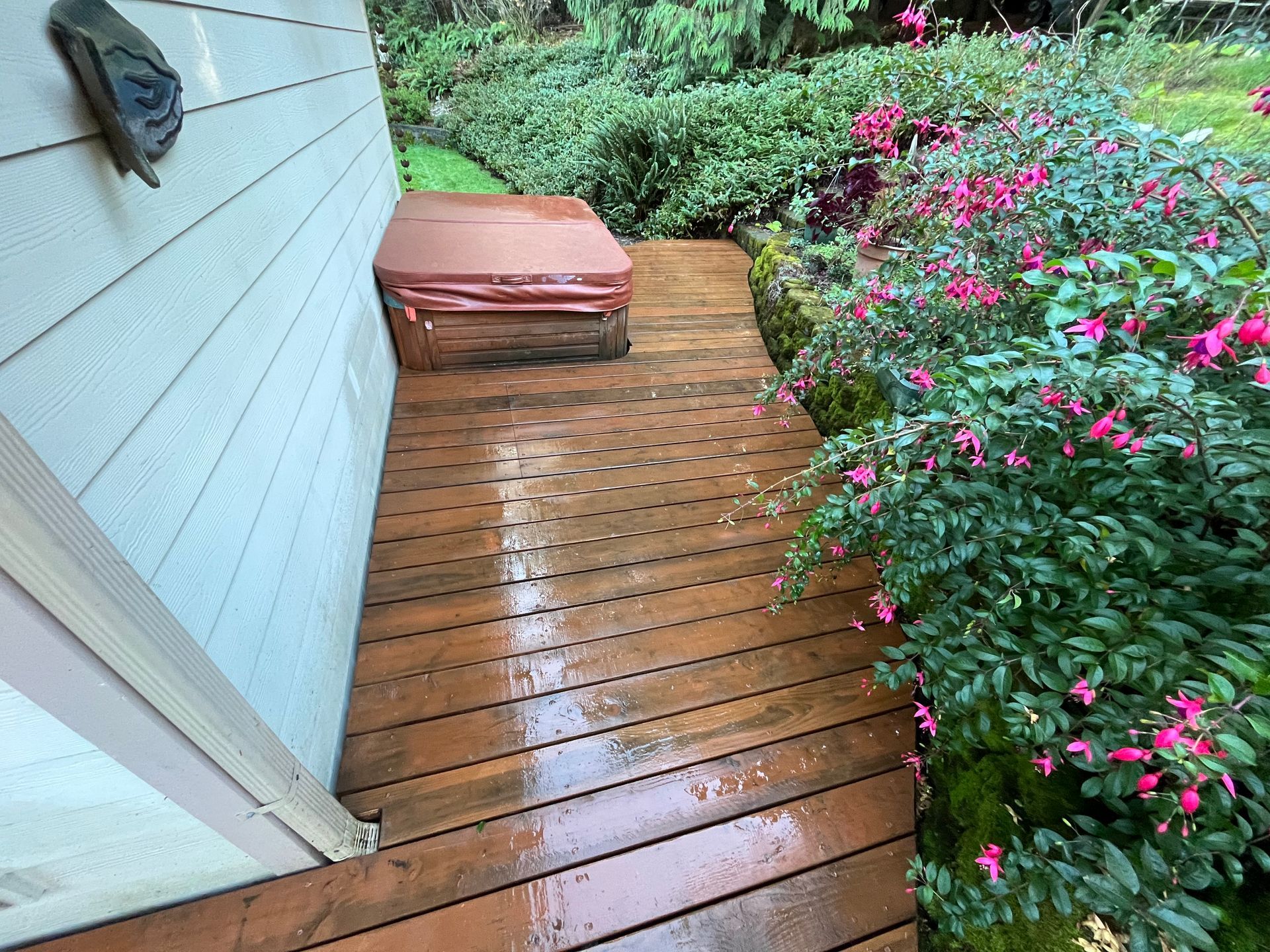 A wooden deck with a hot tub on it next to a house.