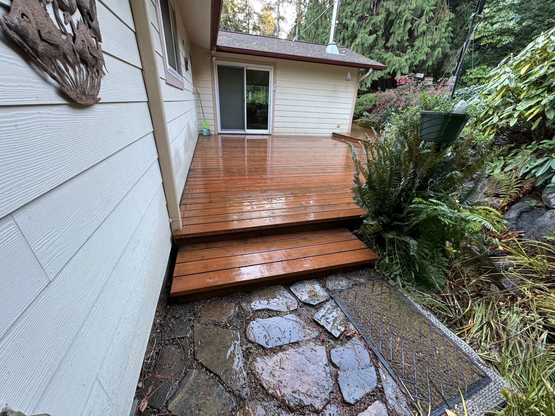 A wooden deck with stairs leading up to it next to a house.