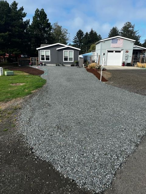 A gravel driveway leading to a mobile home