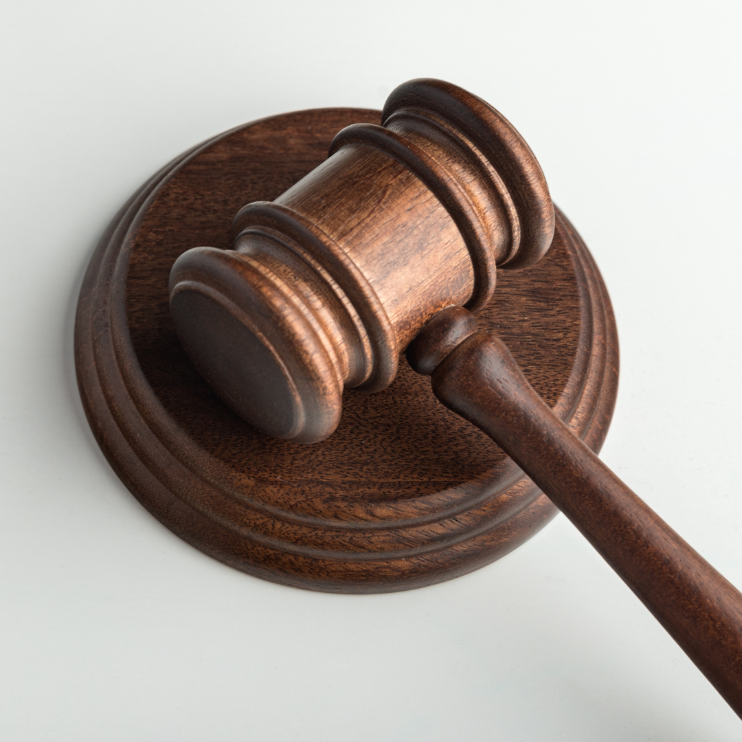 A wooden judge 's gavel is sitting on a white surface