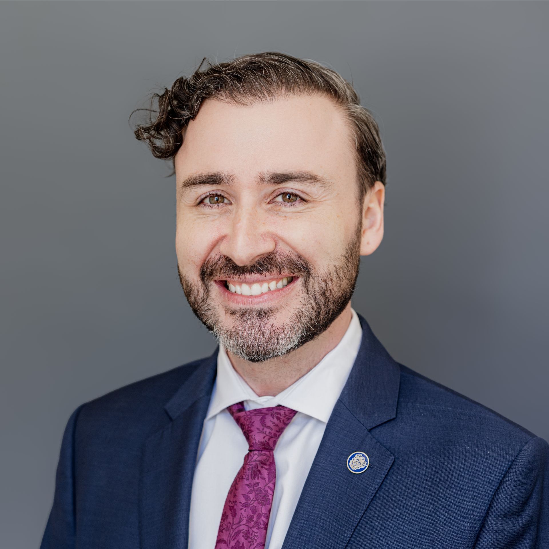 A man in a suit and tie is smiling for the camera.