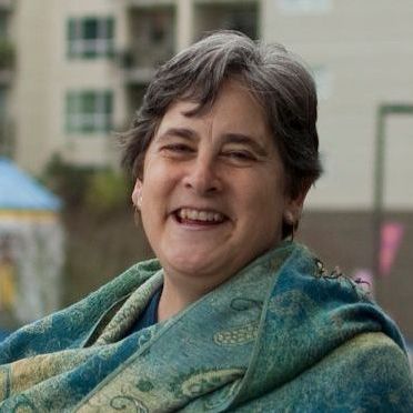 a woman is wrapped in a blanket and smiling .