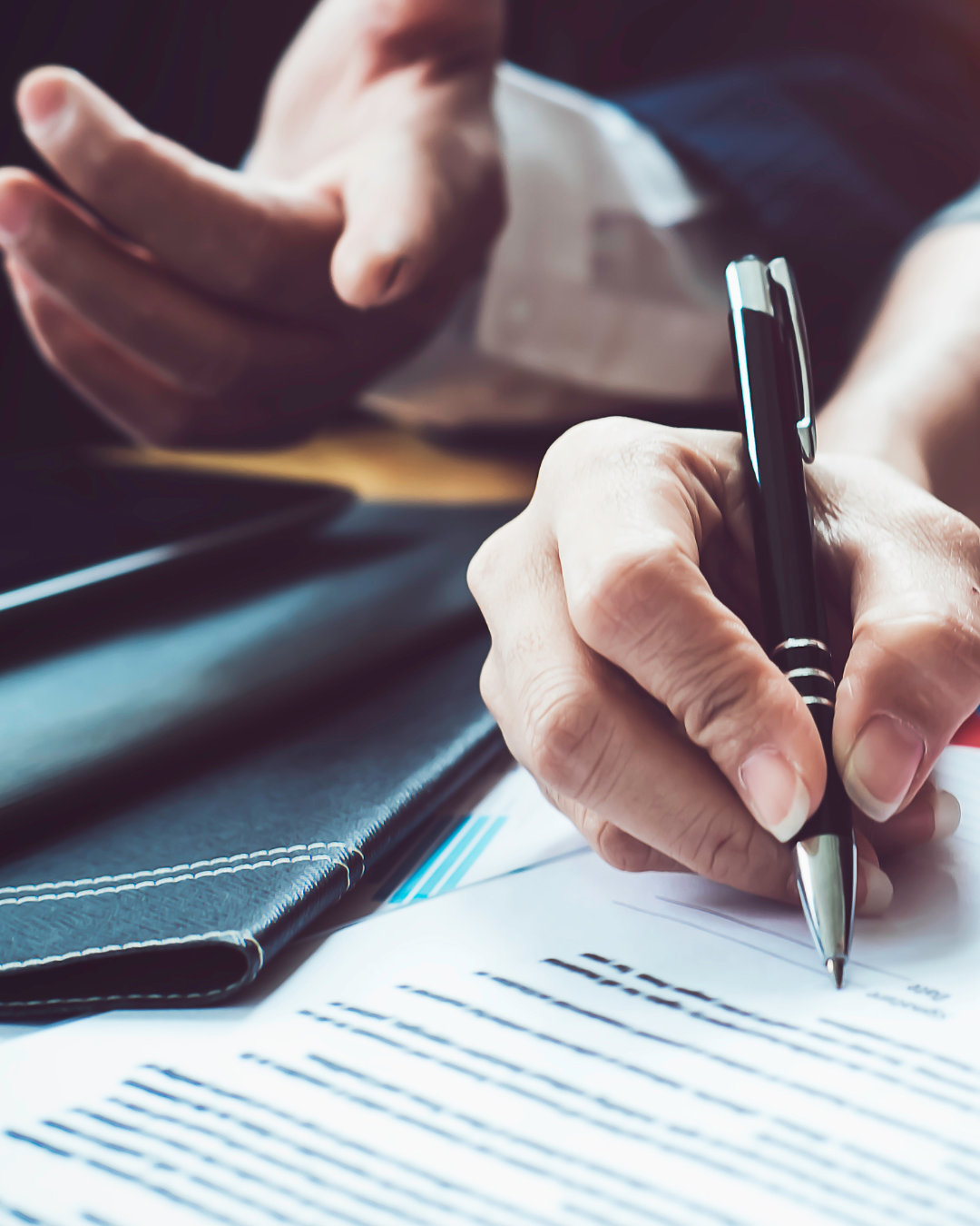 A person is writing on a piece of paper with a pen