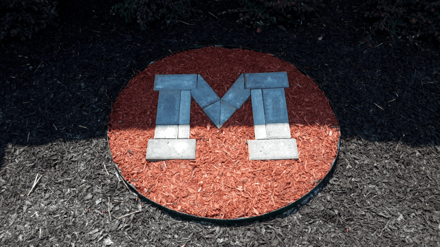 Red and brown circular emblem with blue and white 