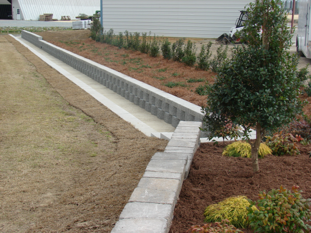 Concrete drainage channel with retaining walls and landscaping.