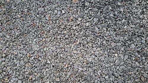 Gravel, small gray stones covering a surface.
