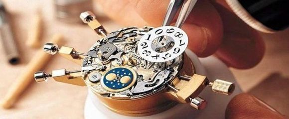 una persona sta riparando il meccanismo di un orologio 