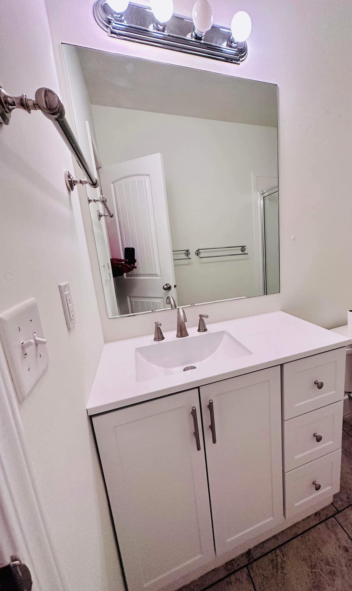 A bathroom with a sink , mirror and shower head.