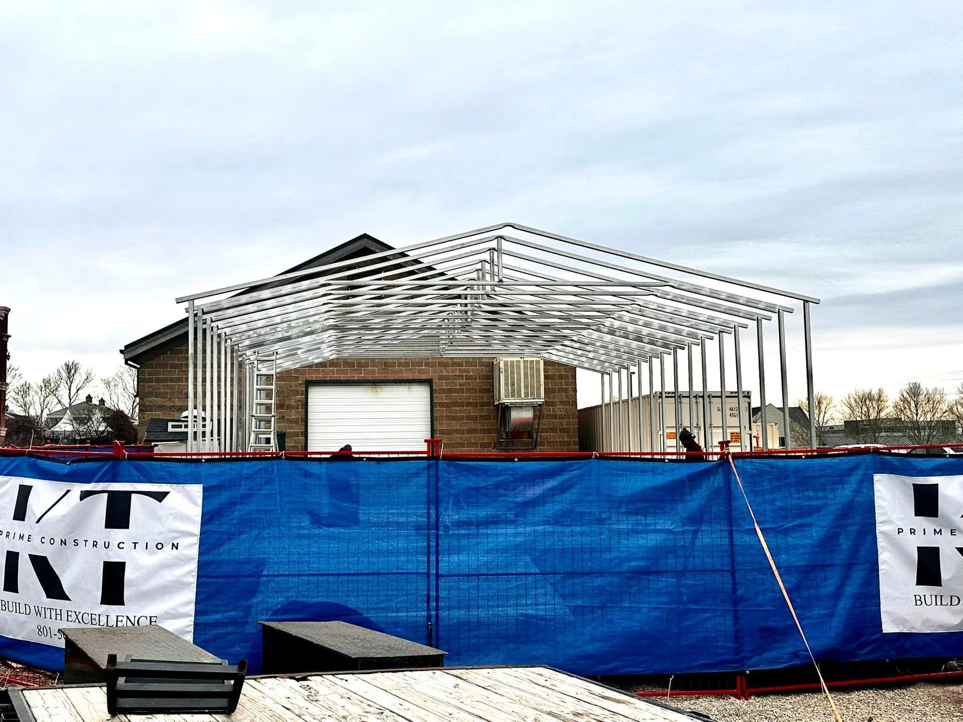 A blue tarp is covering a building under construction
