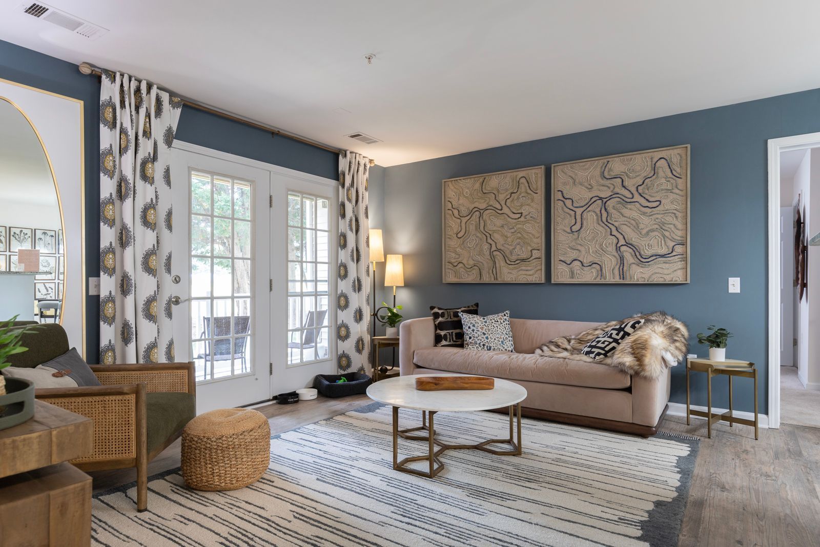 A living room with a couch , chair , coffee table and sliding glass doors.