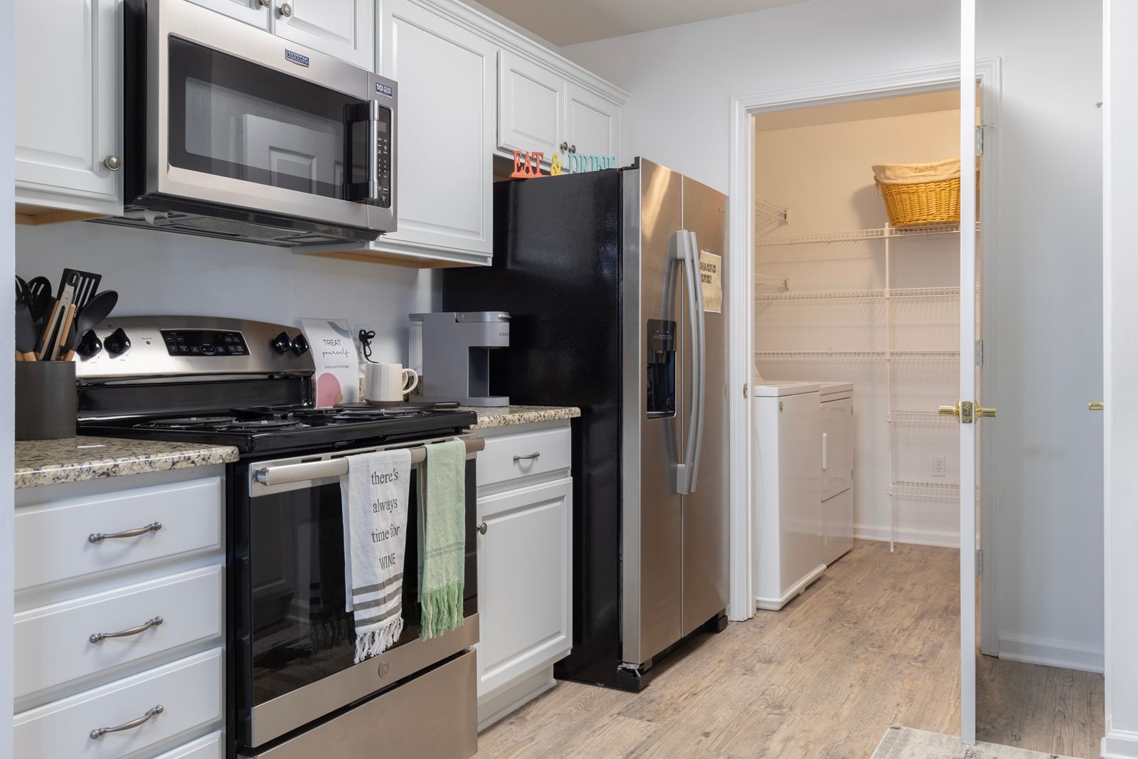 A kitchen with stainless steel appliances and white cabinets.