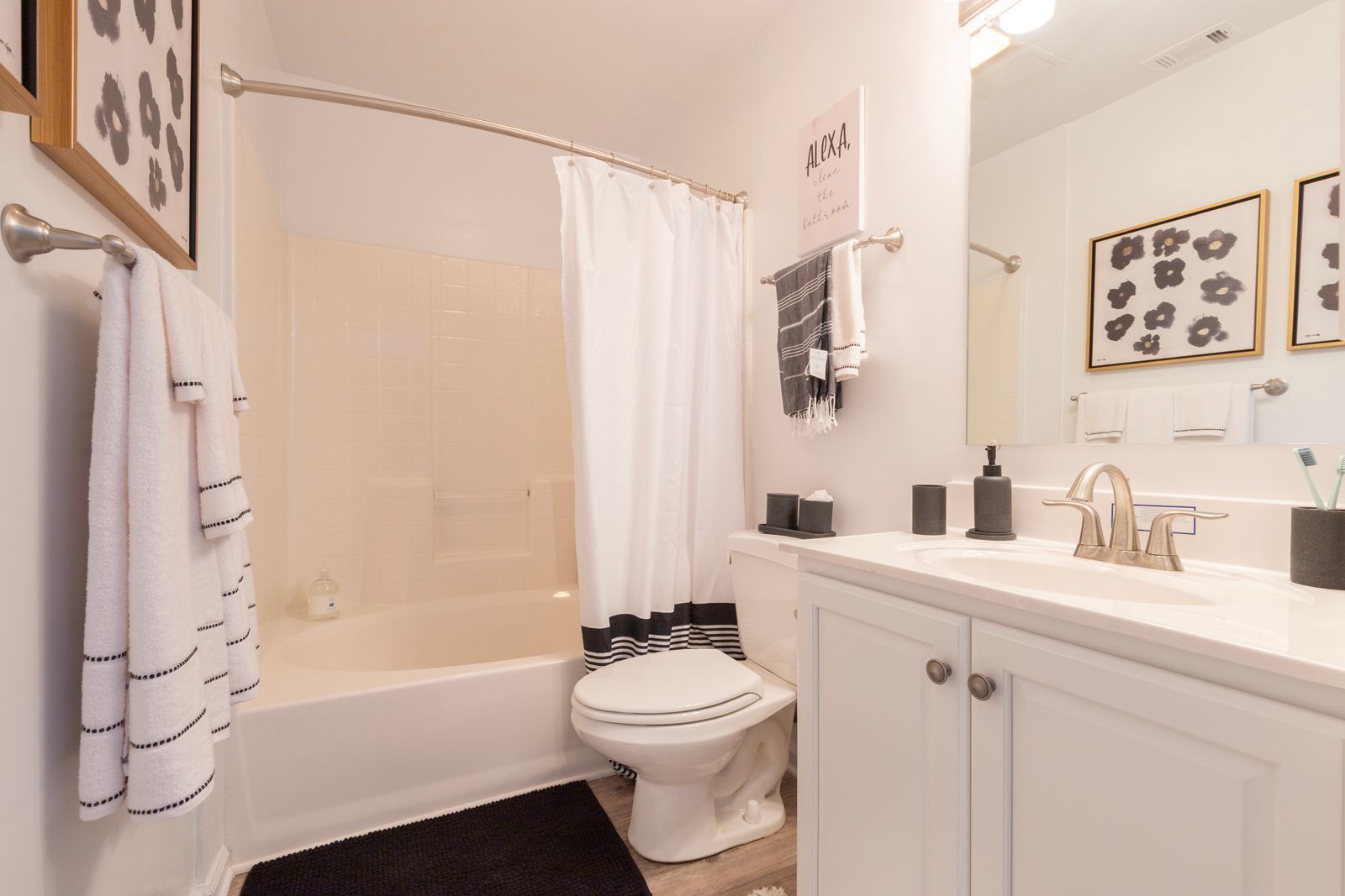 A bathroom with a toilet , sink , bathtub and mirror.