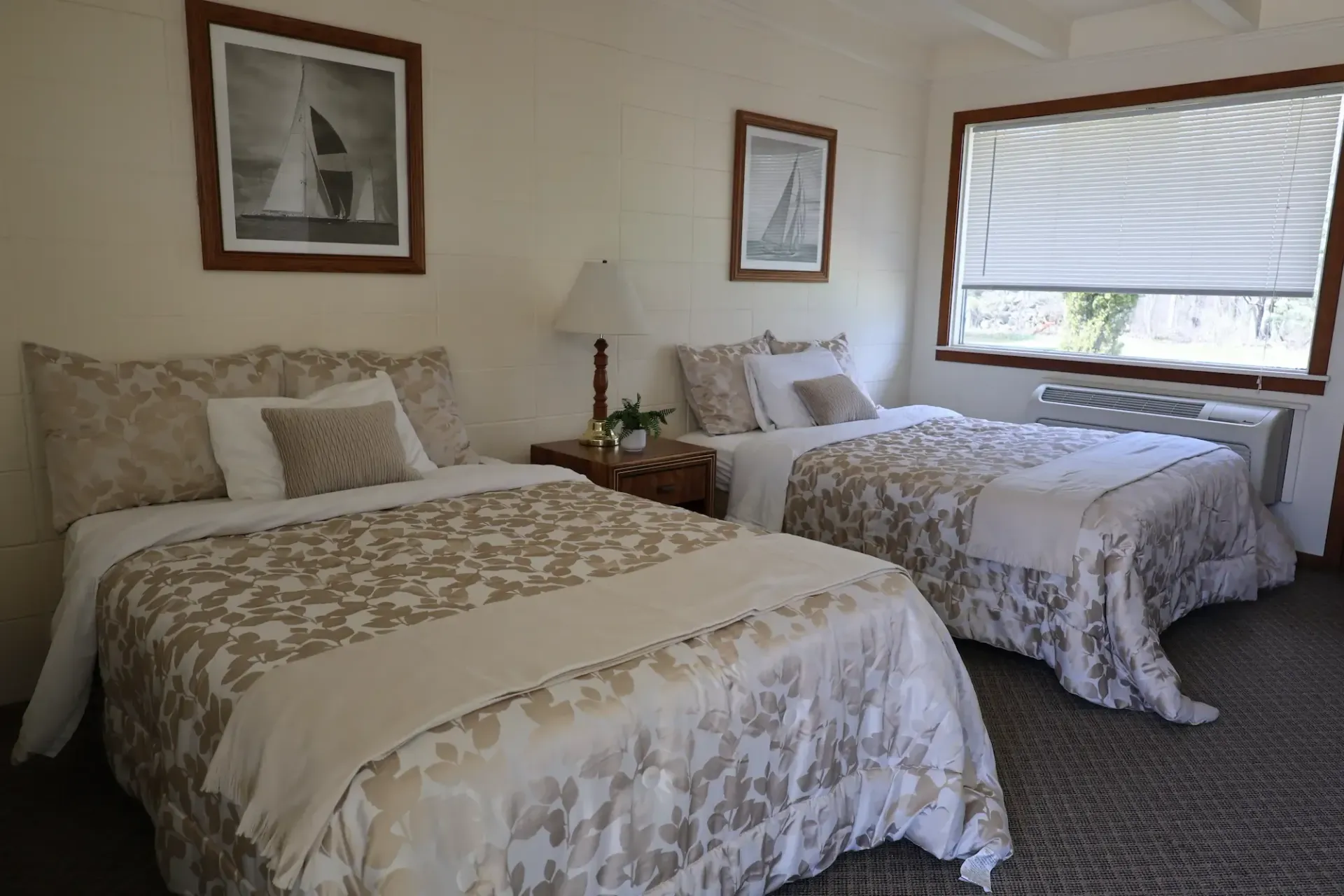 A hotel room with two beds and two pictures on the wall