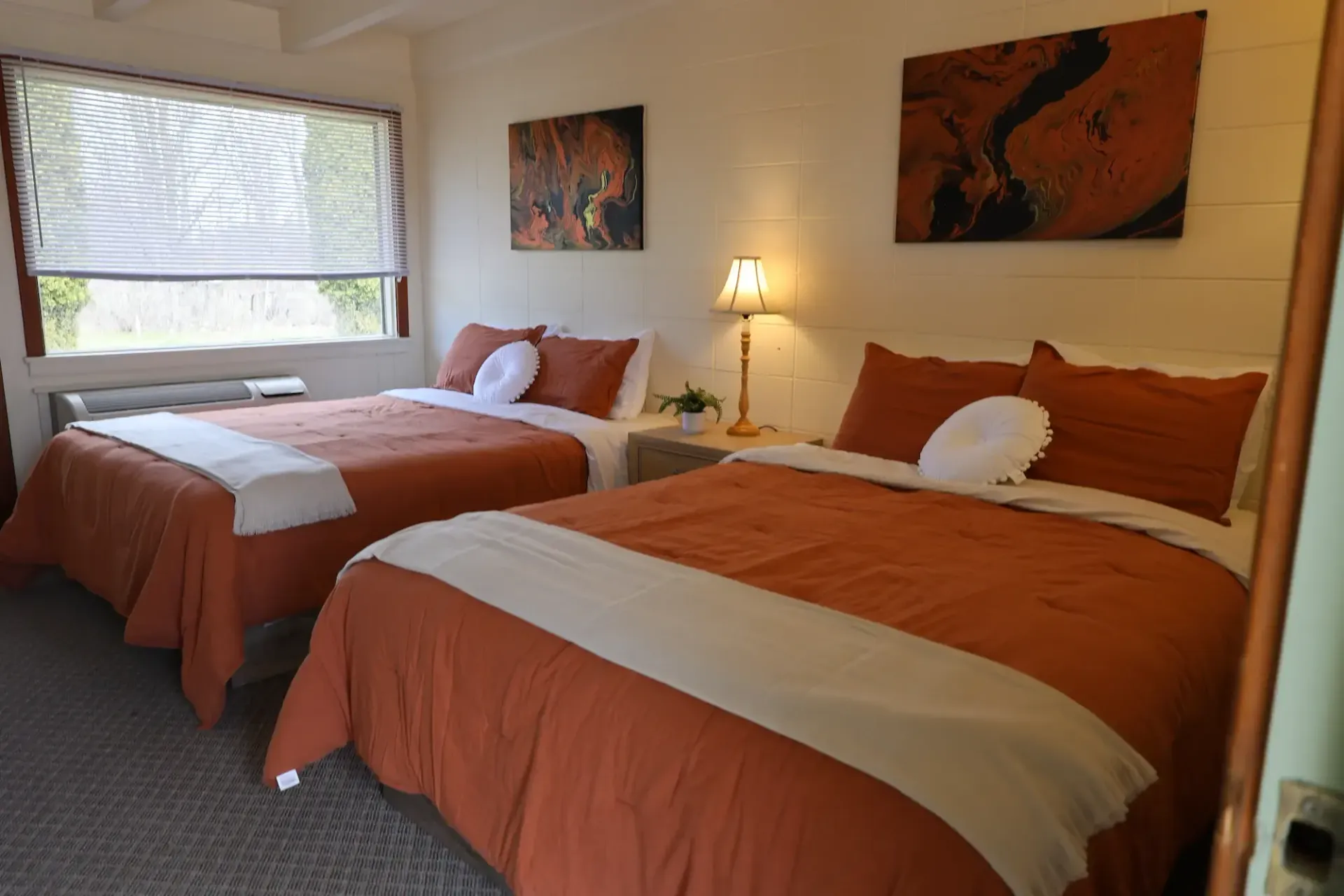 A hotel room with two beds and a window