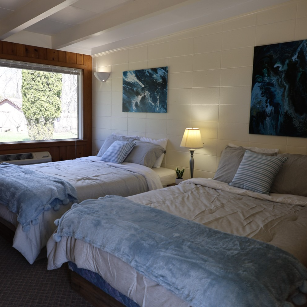 A hotel room with two beds and a lamp