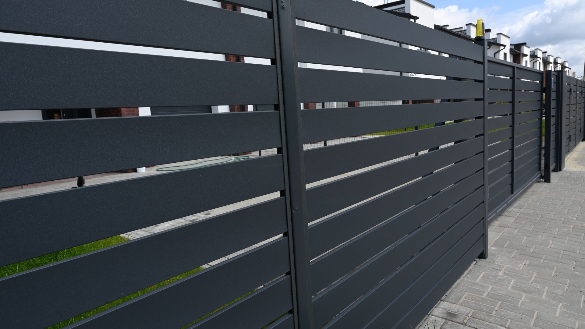 A close up of a black fence on a sidewalk.