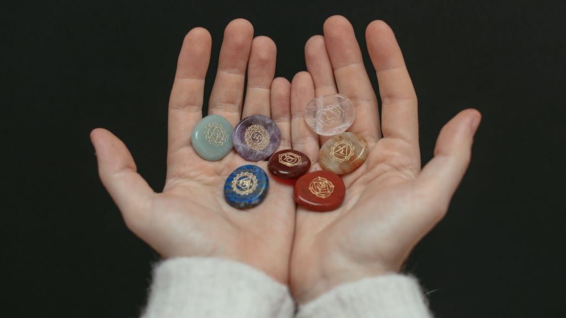 Hands holding chakra stones