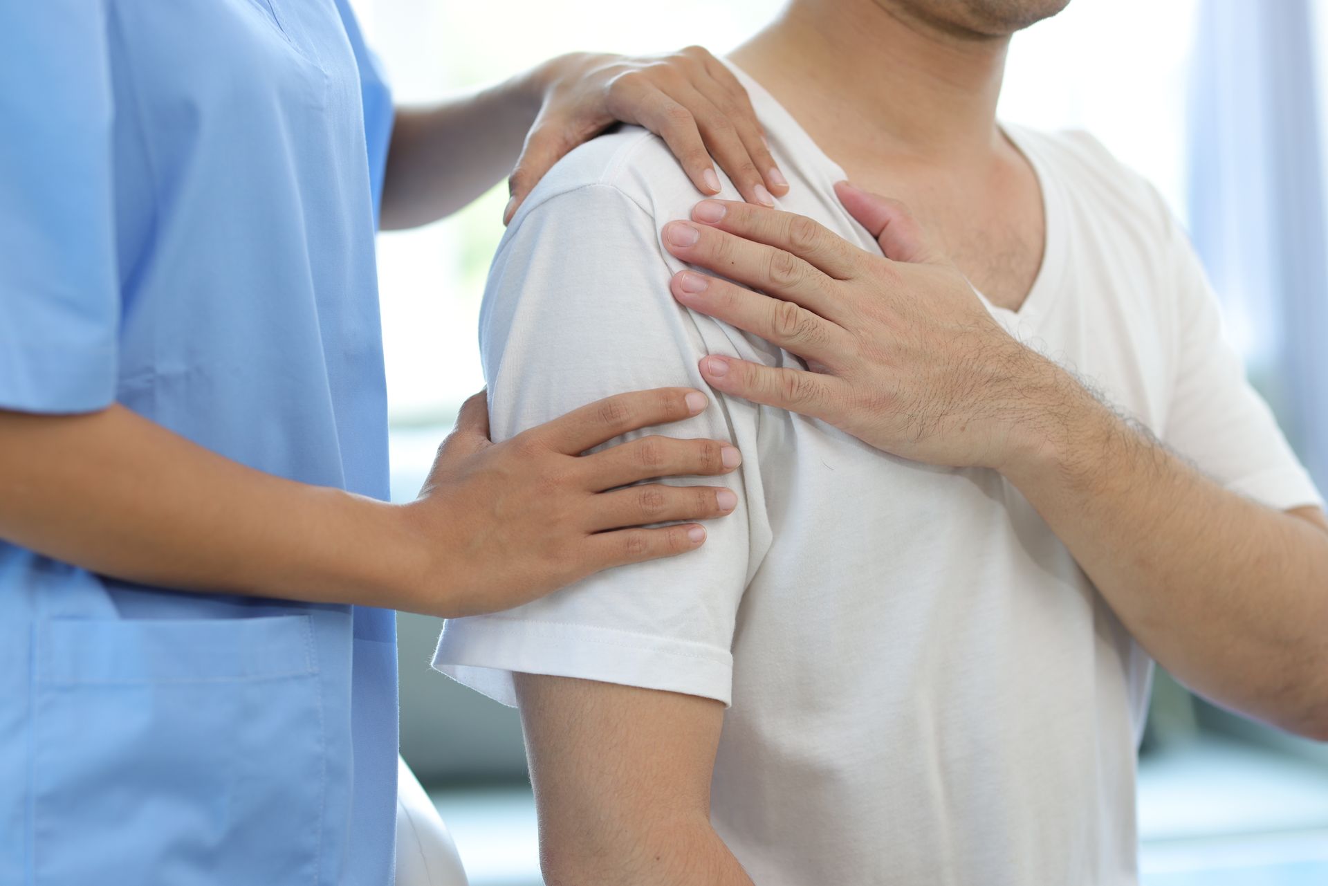 A nurse is putting her hand on a patient 's shoulder.
