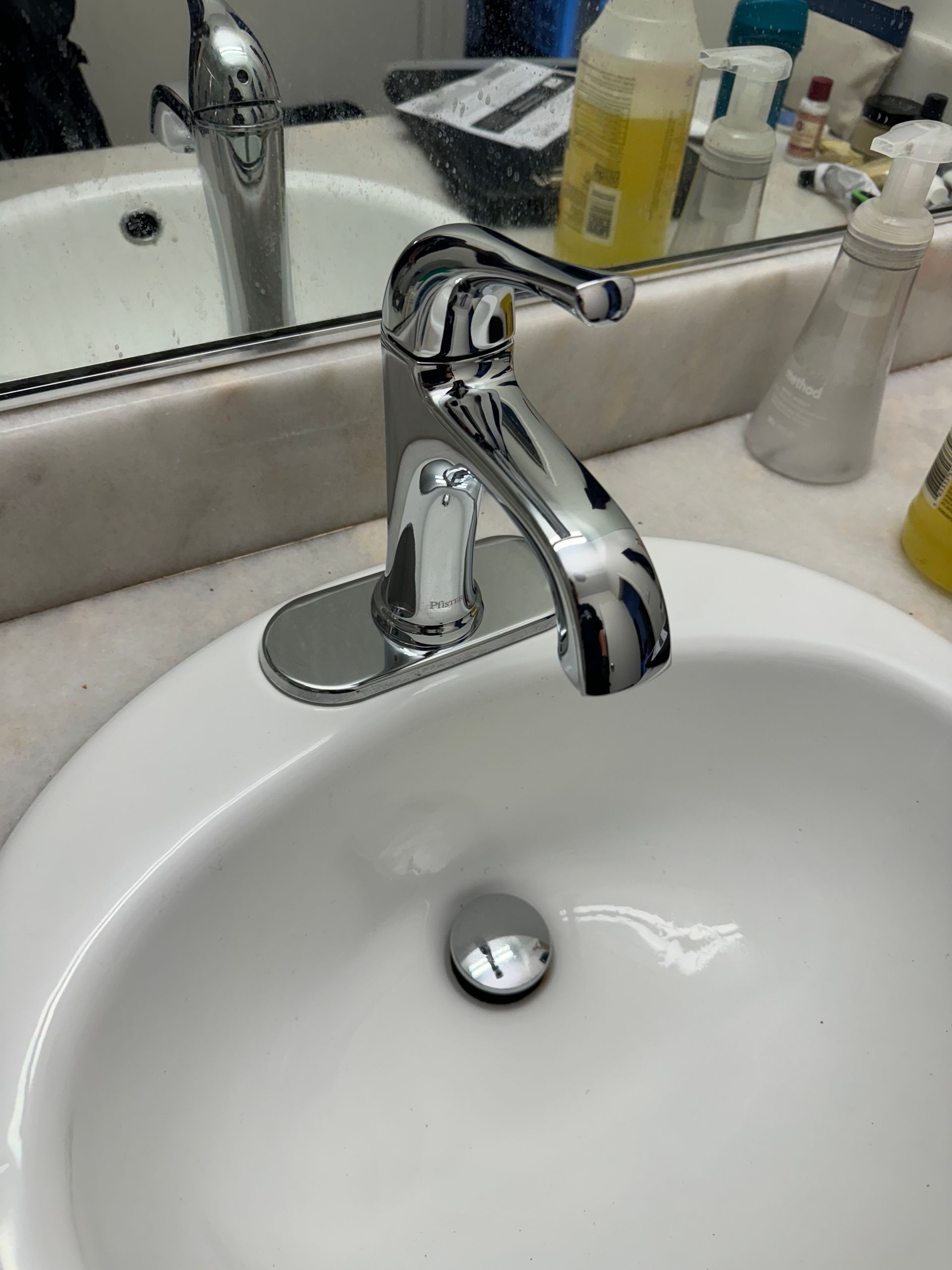 A bathroom sink with a chrome faucet and a mirror.